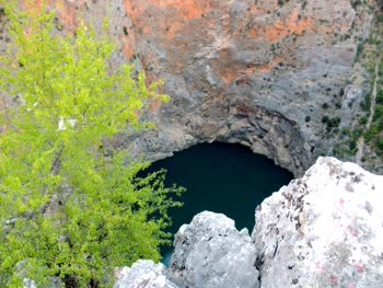 Red Lake, near Imotski, is a stunning natural wonder with its deep red color and sheer cliffs, offering breathtaking views and a popular spot for swimming and diving.